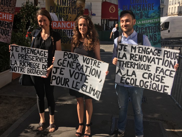 La députée insoumise Clémence Guetté (au centre) pose avec son équipe en tenant des panneaux préparés par les Jeunes pour le climat - © RCF Lyon 2022 (JB Cocagne)